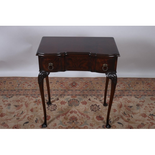 5 - A VINTAGE MAHOGANY SIDE TABLE of serpentine outline the shaped top above a frieze drawer on cabriole... 