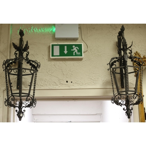 50 - A PAIR OF WROUGHT IRON WALL MOUNTED HANGING LANTERNS each of octagonal form with scroll and spiral d... 
