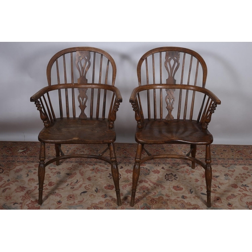 7 - A PAIR OF ELM WINDSOR CHAIRS each with pierced and spindle splats and curved arms with shaped seats ... 