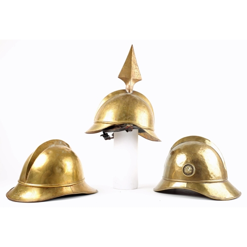 48 - Fireman's helmets. Three brass fireman's helmets, the crowns with combs, the brims with rolled edges... 
