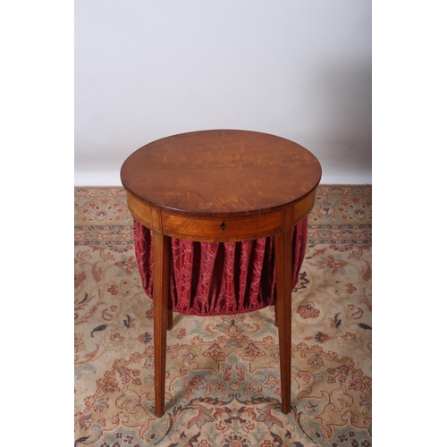 31 - A VINTAGE SATINWOOD SEWING TABLE of oval outline the hinged top above upholstered basket on square t... 