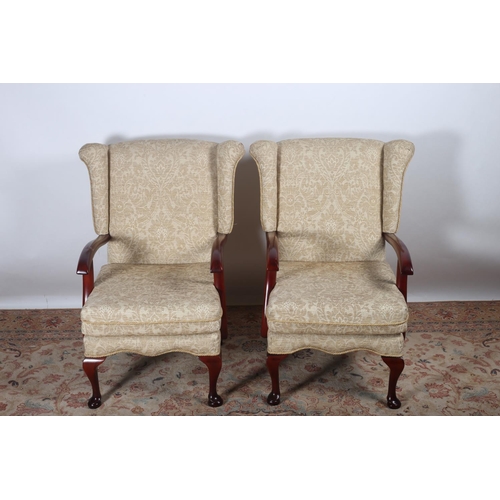 35 - A PAIR OF PARKER KNOLL DESIGN STAINED WOOD AND UPHOLSTERED WING CHAIRS with loose cushions and scrol... 