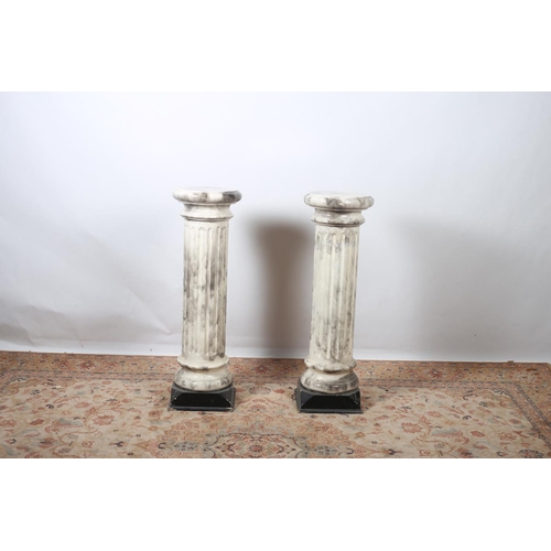 40 - A PAIR OF PINE AND MARBLISED PEDESTALS each with a circular top above a stop fluted column on square... 