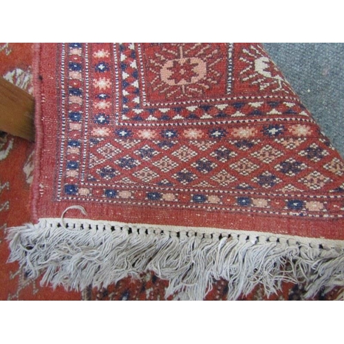 512 - MIDDLE EASTERN RUG, with multiple medallions on a red ground within multiple borders, 68
