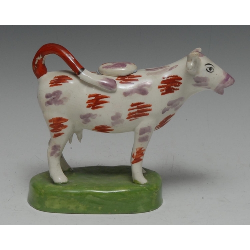 12 - A 19th century Swansea type cow creamer, purple lustre and iron red patches, oval green base, 18.5cm... 