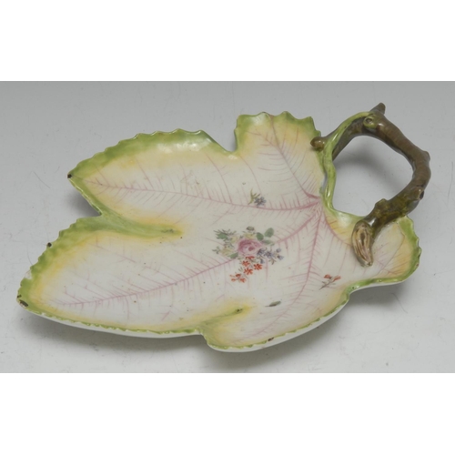56 - A  Chelsea leaf shaped dish, painted with flowers and sprigs, veins in puce, branch loop handle, gre... 
