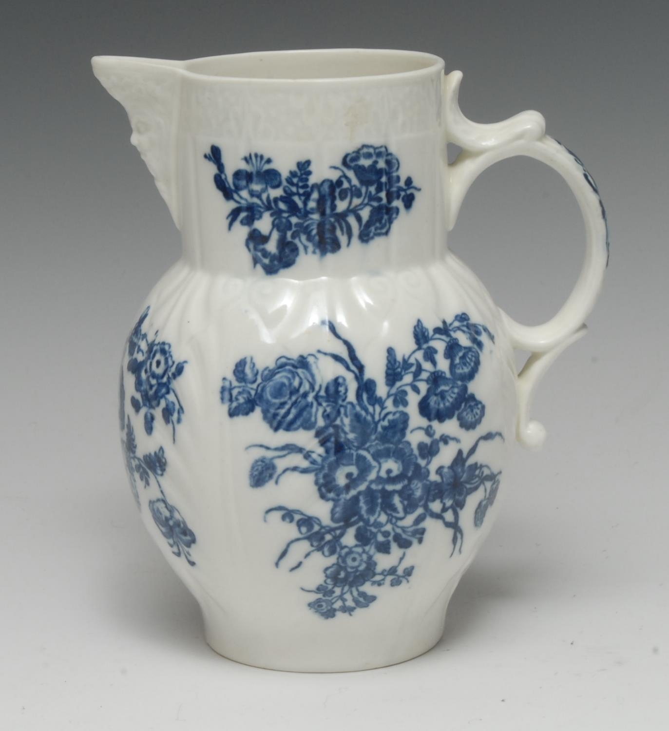 A Caughley cabbage leaf moulded mask jug, printed in underglaze blue with...