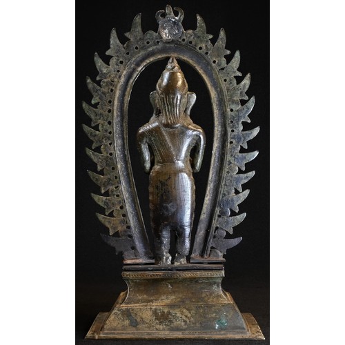 5040 - A 19th century Indian shrine figure, cast as a deity, standing, beneath a nimbus, rectangular base, ... 