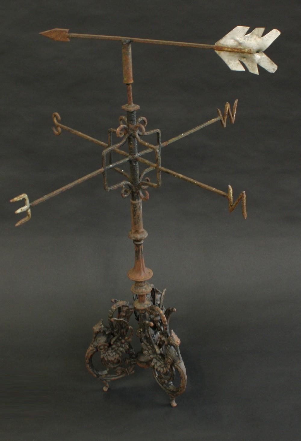 A 19th century cast metal weather vane, triform base cast with winged ...