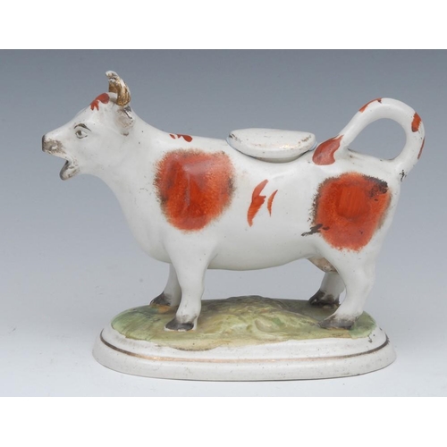 15 - A 19th century Staffordshire cow creamer, standing four square, tan patch markings, oval base, 12cm ... 