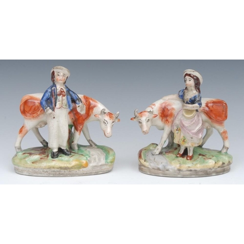 15A - A pair of Staffordshire models, of a milkmaid and milk boy, standing before cows, oval bases, 16cm h... 