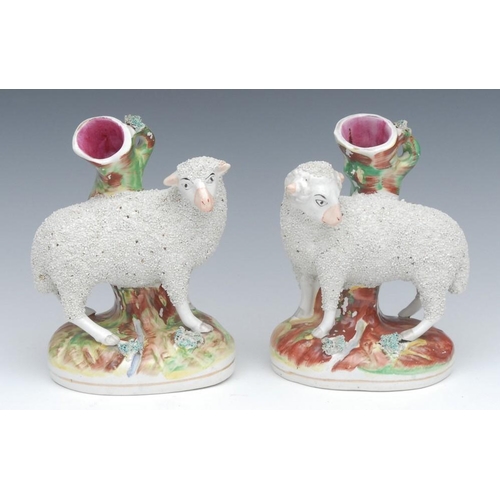 29 - A pair of Staffordshire spill vases, of sheep, standing to the left and right, shredded clay coats, ... 