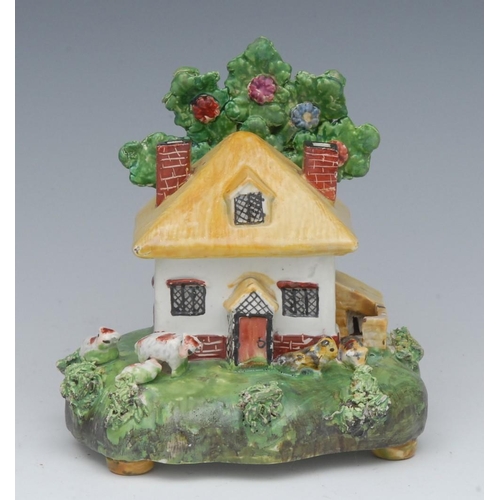 38 - A Staffordshire pot pourri, in the form of a thatched cottage, before a tree, with pig sty, pigs, sh... 