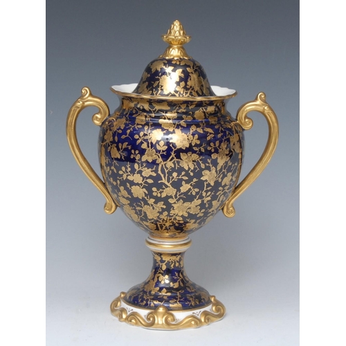 53 - A Coalport two handled pedestal urnular vase and cover, decorated overall with gilt scrolling foliag... 