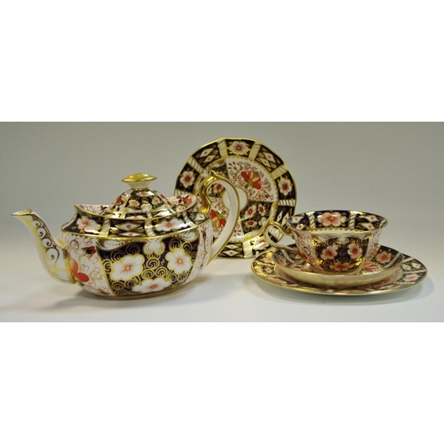 11 - A Royal Crown Derby 2451 teapot; a 2451 trio, another cabinet saucer (5)