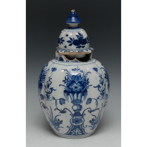 13 - A Dutch Delft lobed ovoid vase and cover, decorated in underglaze blue with stylised flowers, vases ... 