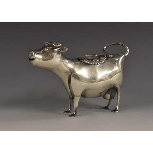 50 - A Continental silver cow creamer, in the manner of John Schuppe, she stands, the hinged cover creste... 