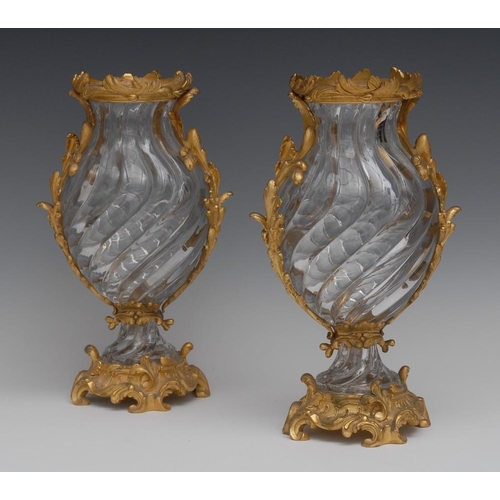 14 - A pair of Rococo design ormolu mounted crystal wrythen ovoid mantel vases, possibly Baccarat, the mo... 