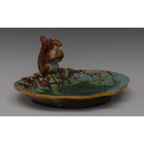 5 - A George Jones majolica Squirrel nut dish, moulded with squirrel holding an acorn, the shaped dish i... 