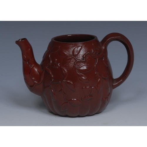 19 - An 18th century  red moulded stoneware lobed globular tea pot, moulded in low relief with blossoming... 