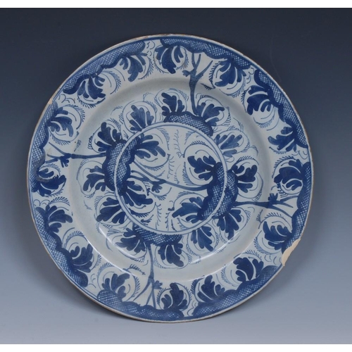2A - An English Delft circular plate, decorated in underglaze blue with roundel stylised leaves and trell... 