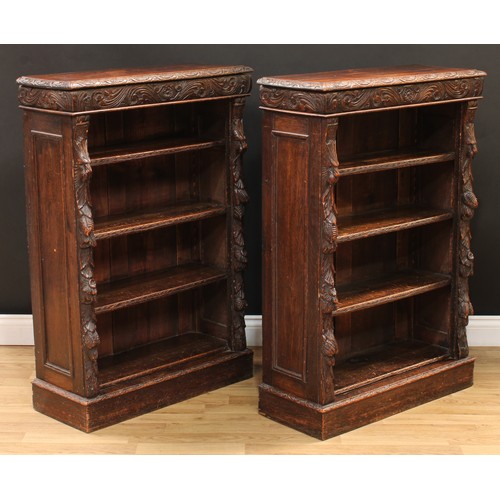 18 - A pair of late Victorian oak pier library bookcases, each with a rectangular top with floral lunette... 