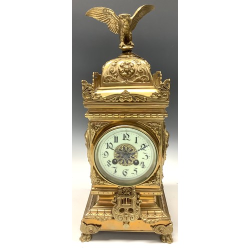 47 - A 19th century brass mantel clock, the case embossed with masks and scrolls, eagle finial, Arabic nu... 