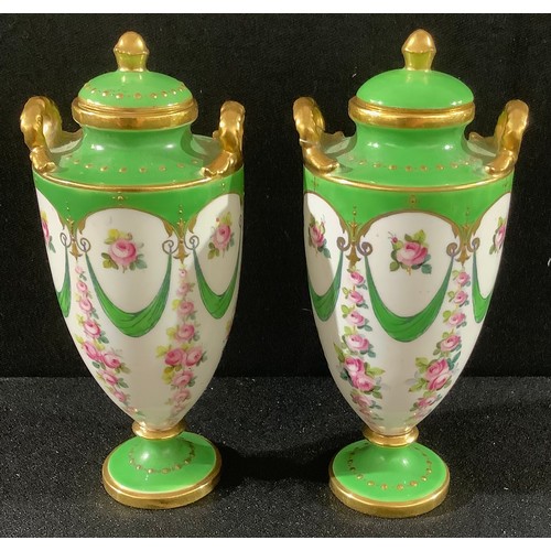16 - A pair of miniature Minton pedestal two handled vases and covers, printed and painted with garlands ... 
