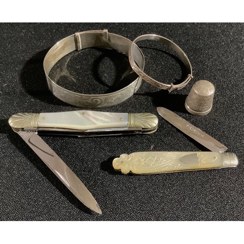 36 - A silver and mother-of-pearl fruit knife;  a pen knife;  a silver thimble;  silver bangles;  etc