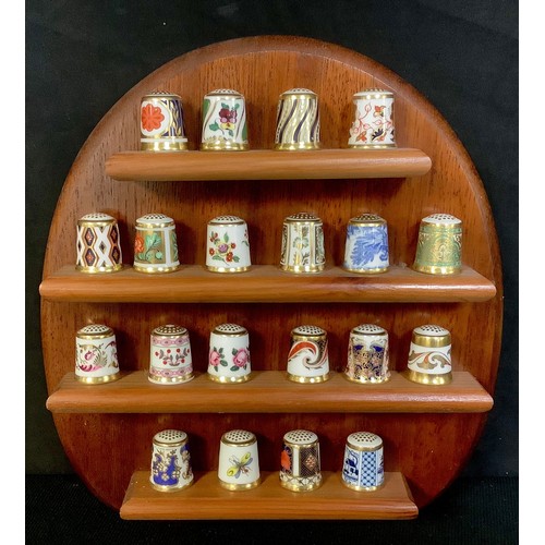 9 - A set of twenty Royal Crown Derby thimbles, assorted patterns, on a wooden wall rack