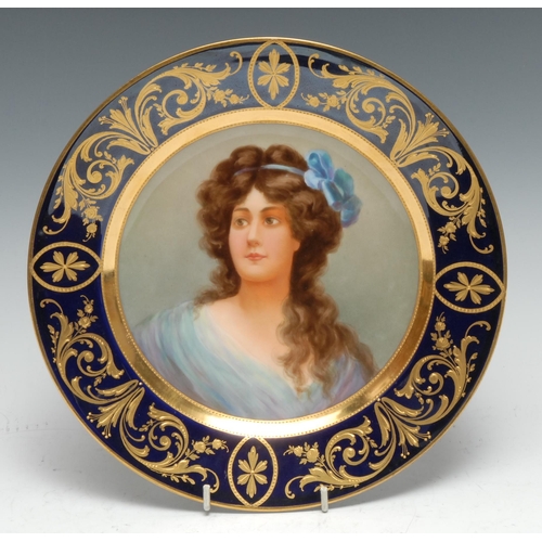 11 - A Vienna circular plate, painted with a beauty, with a blue ribbon in her hair, cobalt blue border a... 