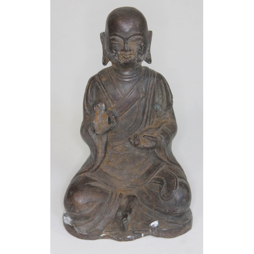 374 - A Bronze buddha seated and holding a rat, height 16cm.