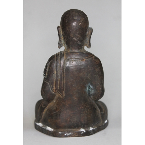374 - A Bronze buddha seated and holding a rat, height 16cm.