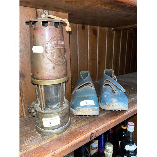 1 - A pair of vintage clogs and a miner's pit lamp.