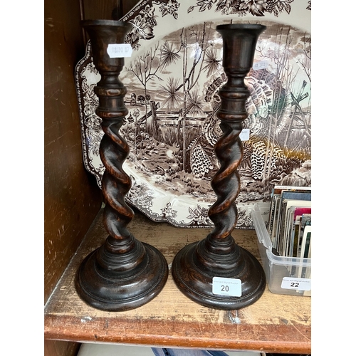 20 - A pair of twist carved wood candlesticks.