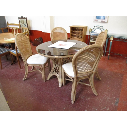 A circular glass top cane dining table together with four ma... Barnebys