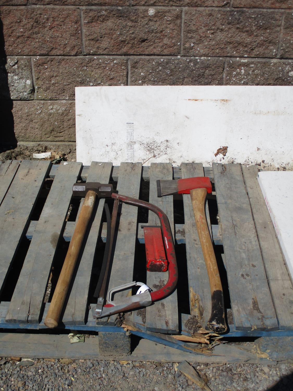 A felling axe, a wedge, a bow saw and a sledge hammer