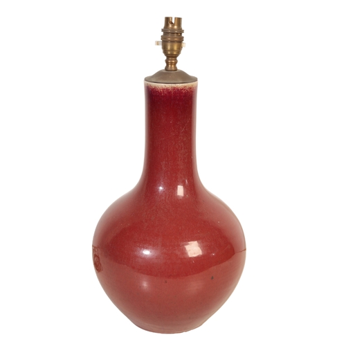 714 - A CHINESE OXBLOOD VASE converted to a lamp, 38cm high, with damage to the top of the neck

The estat... 