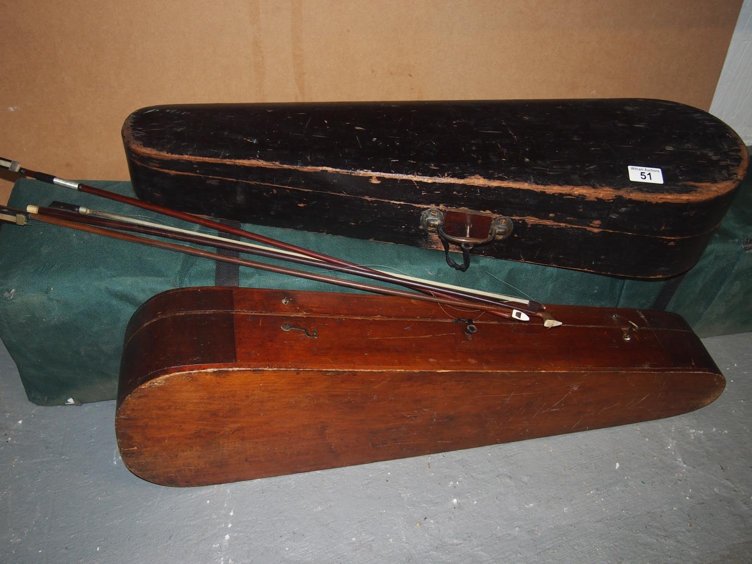 Two antique wooden coffin style violin cases with keys and three bows