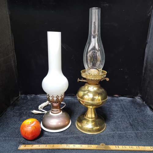 673 - One vintage brass oil lamp with a clear glass chimney. With a second electric lamp in the same style... 