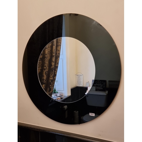 53 - A very large circular mirror with thick black glass frame.
