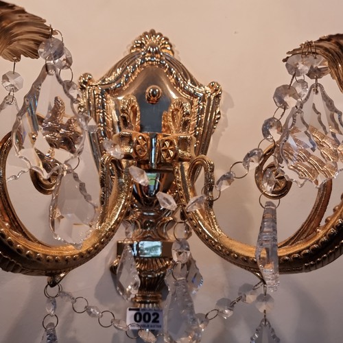 2 - A pair of Italian opulent brass two-branch wall sconces adorned with leaf-drop crystals in beautiful... 