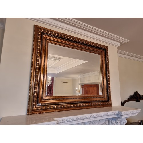 15 - A huge bevelled thick framed over-mantle mirror with broad gilt frame. Beautifully carved. H116cm x ... 