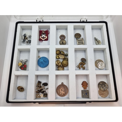 27 - A presentation case containing a good assortment of vintage military and tunic badges.