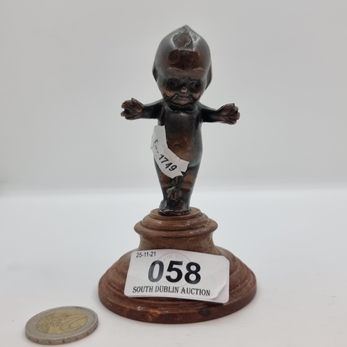 58 - An attractively carved bronze cherub figure mounted on wooden base. Height 11cm. Total weight 275.4g... 