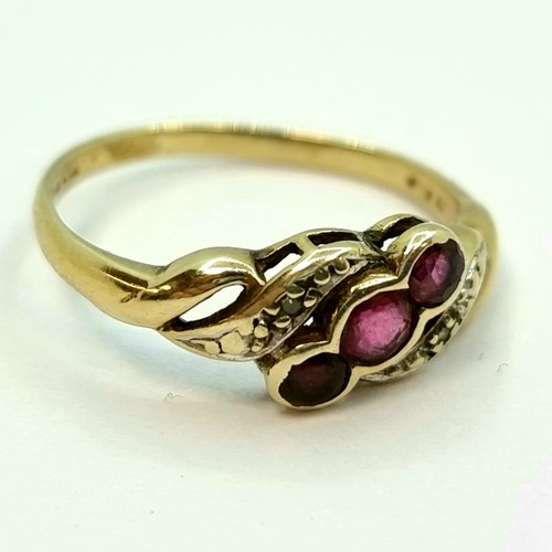 3 - A nice example of a 9K gold three stone ruby ring with diamond shoulders on twist setting. Ring size... 