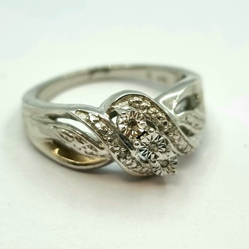 5 - A very fine three stone diamond ring with twist set diamond shoulders. Set in sterling silver. Total... 