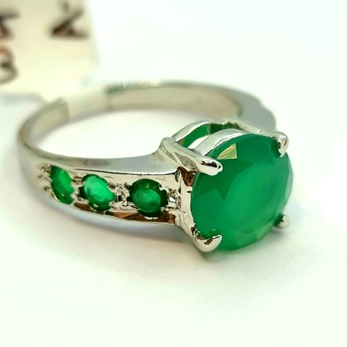 13 - Star Lot: A large emerald stone ring with six additional emerald stones to shoulders. Ring size O 1/... 