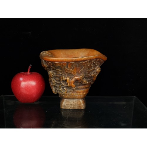 A Chinese libation cup, with seven lively chilongs in relief clambering along the rim and exterior. With a stunning Greek key pattern to base and chilong head curving over the rim. A Qianlong reign mark is present to the base. 
H 11.5cm x W 13cm.