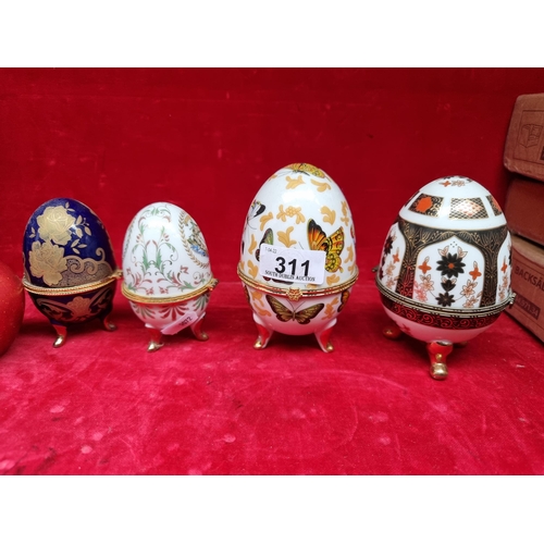 A collection of three pretty ceramic eggs, including a lovely hand painted Limoges example. All gilt footed and nicely decorated.